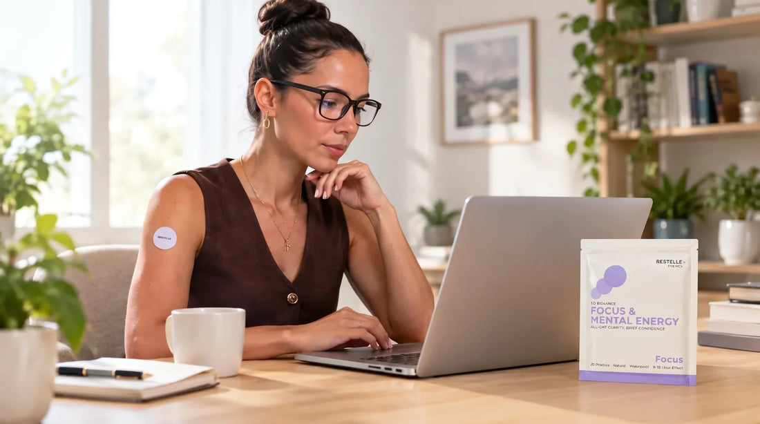 Professional woman working on a laptop with a Restelle focus patch applied to her arm next to the product packaging.