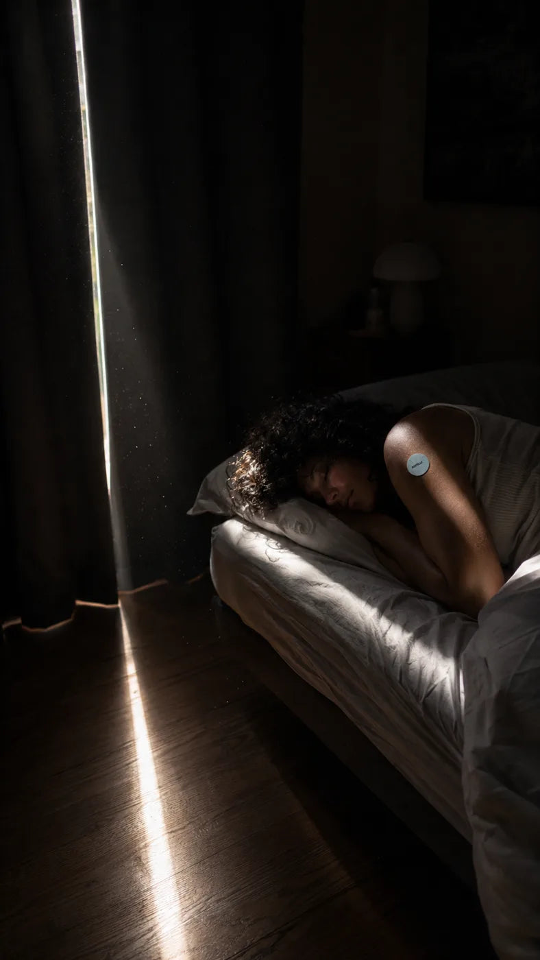 A blade of daylight cutting across the floor while a woman sleeps soundly with a RESTELLE patch